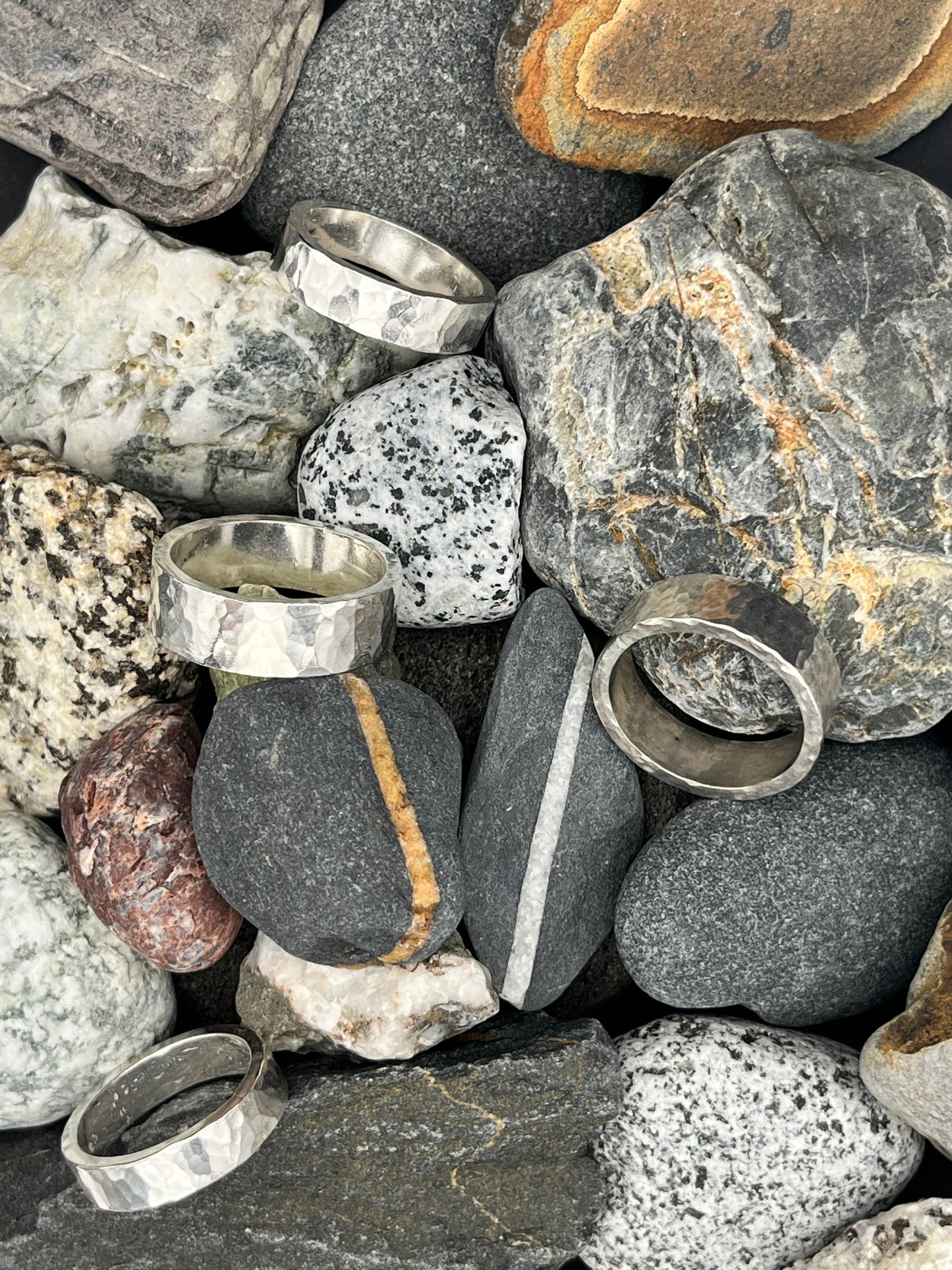 Silver rings on a pile of rocks