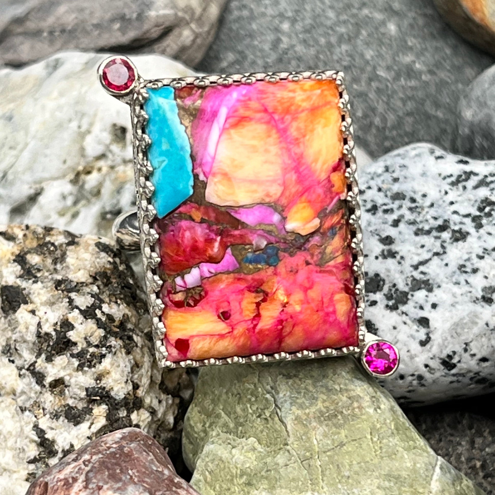 Multicolored stone with embedded gemstones on a bed of rocks